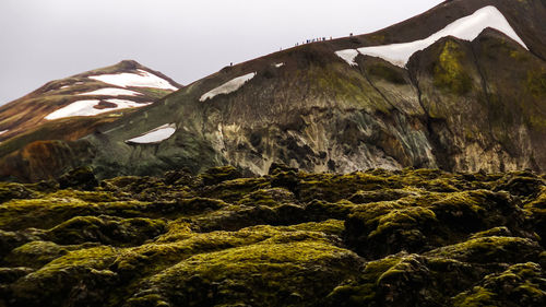 Low angle view of rocks on mountain against sky