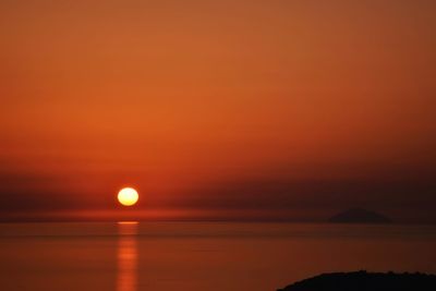 Scenic view of sea against orange sky