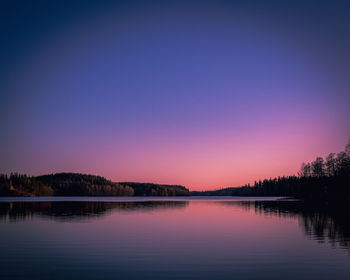 Scenic view of lake against clear sky at sunset