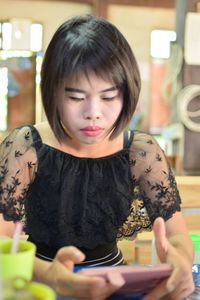 Woman using smart phone in restaurant