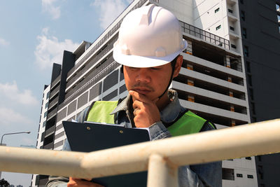 Low angle view of man holding smart phone