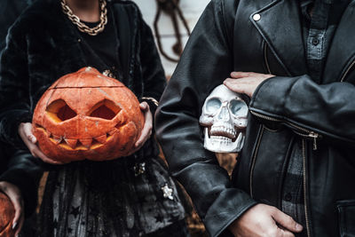 Midsection of man holding pumpkin