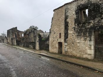 Road amidst buildings in city against sky