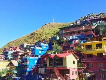 Houses in town against clear blue sky