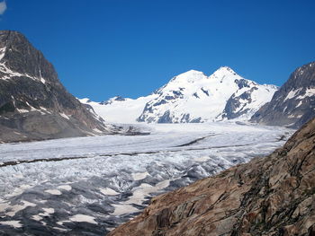 Scenic view of snowcapped mountains against clear blue sky