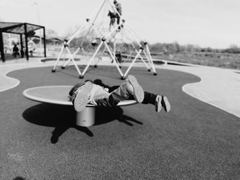 Rear view of boys playing on merry-go-round at playground