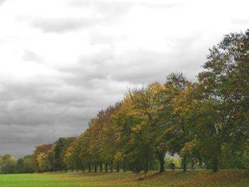 Scenic view of grassy field against cloudy sky