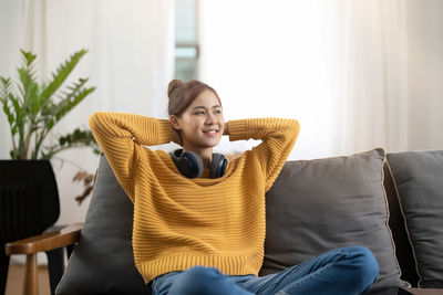 Portrait of woman sitting on sofa at home