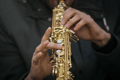 Midsection of man playing guitar