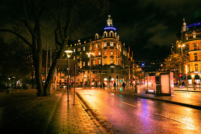 Illuminated city street and buildings at night