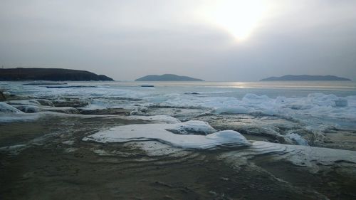 Scenic view of sea and mountains against sky