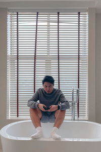 Full length of young man standing in bathroom