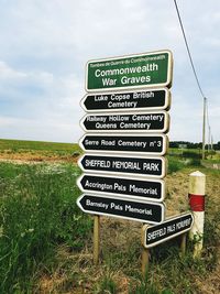 Information sign on field against sky