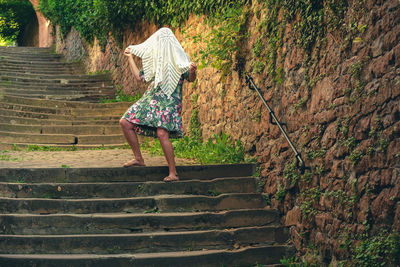 Rear view of woman walking on staircase