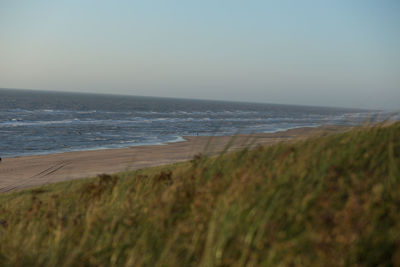 View of calm beach against clear sky