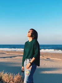 Man standing on beach against clear sky