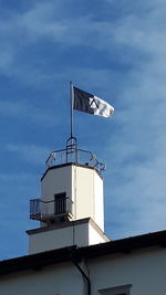 Low angle view of weather vane against building