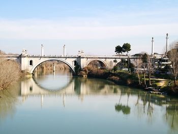 Reflection of bridge on water against sky