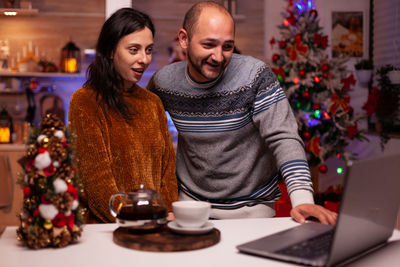 Smiling couple using laptop during christmas