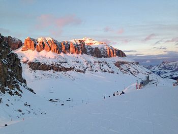 Group of people on snowcapped mountain against sky