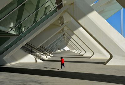 Rear view of child running in corridor