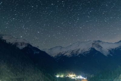 Scenic view of snowcapped mountains against sky at night