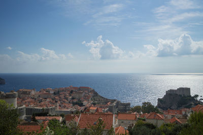 Scenic view of sea and houses against sky