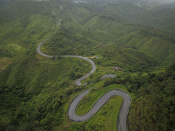 Countryside road passing through the lush green tropical rain forest mountain landscape