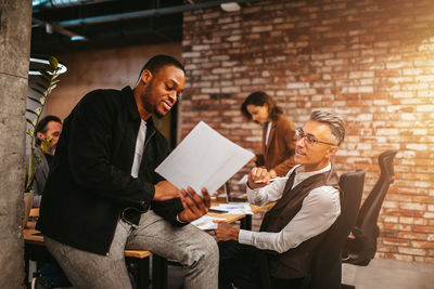 Business colleagues discussing over document at office