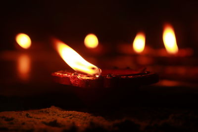 Close-up of lit candles in the dark