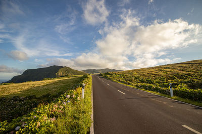 Road at flores island, wonderful day, green vegetation, clouds.