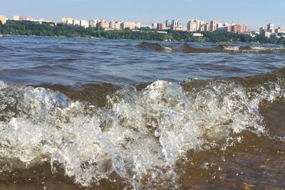 Scenic view of sea against buildings in city