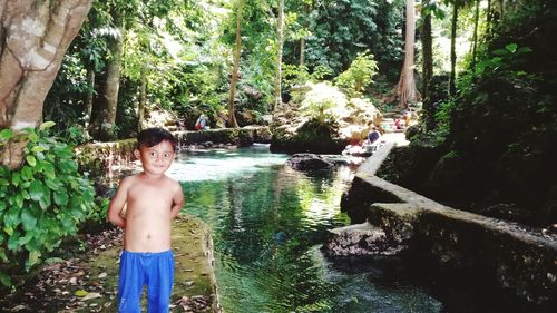 Full length of shirtless boy standing in water