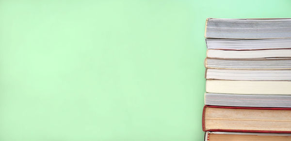 Close-up of books on table against wall