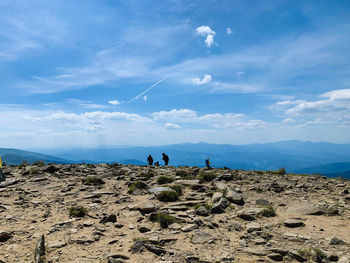 People on mountain against sky
