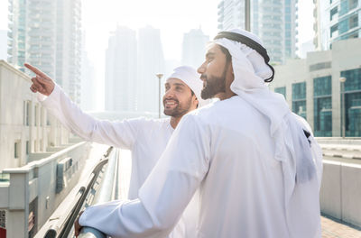 Friends standing by buildings in city