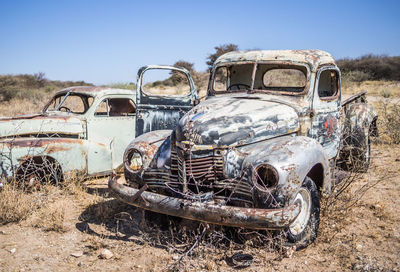 Abandoned cars against sky