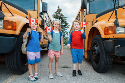 Proud happy children students boys and girl holding waving canadian flags. education back to school