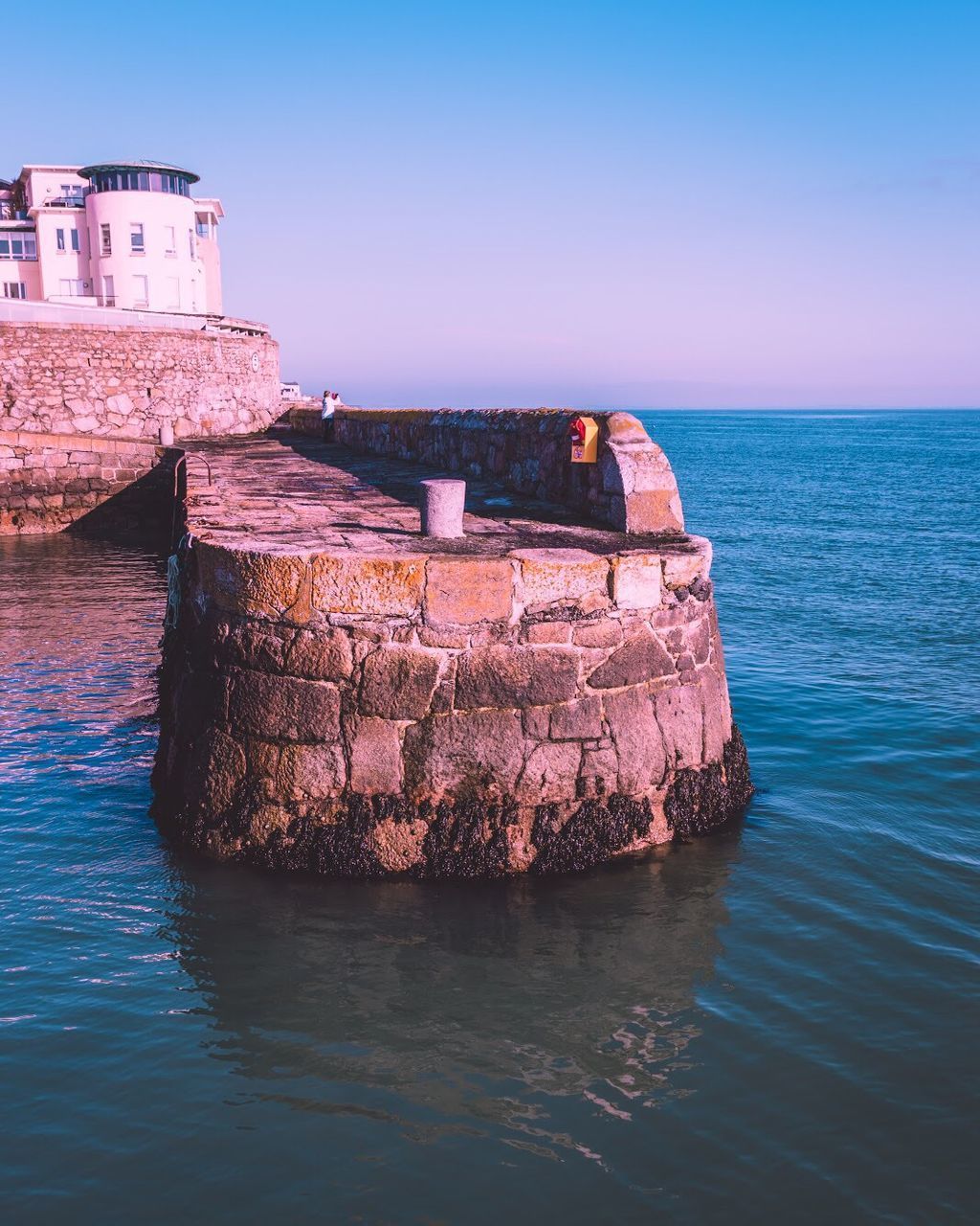 VIEW OF ROCKS IN SEA AGAINST CLEAR SKY