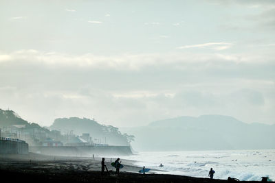 People on beach against sky
