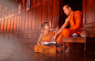 Full length of father and son sitting on table