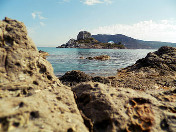 Scenic view of sea by cliff against sky