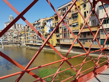 Bridge over river against buildings in city