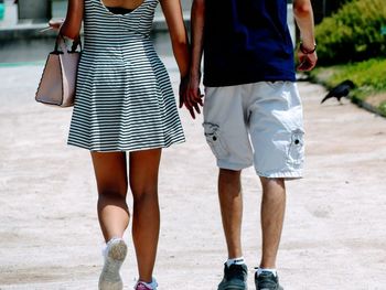 Rear view of couple walking on footpath