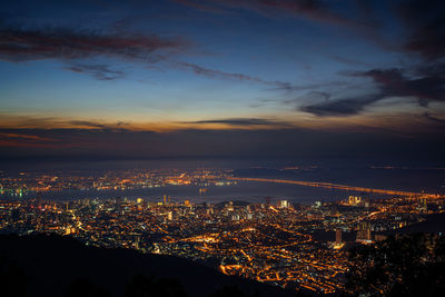 Aerial view of illuminated cityscape against sky at night