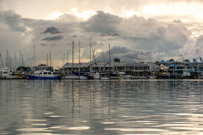 Sailboats moored at harbor against sky during sunset, silver environments 