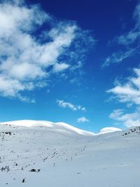 Scenic view of snowcapped mountains against blue sky