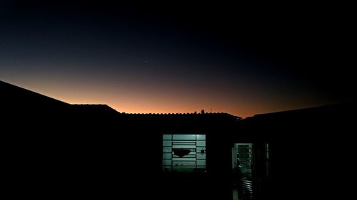 Silhouette built structure against sky at sunset