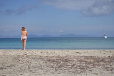 Rear view of woman standing on beach
