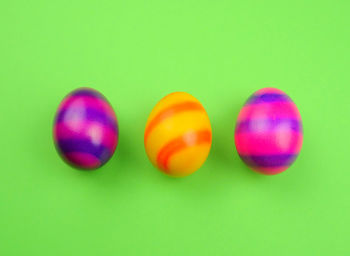 Close-up of multi colored balloons against green background